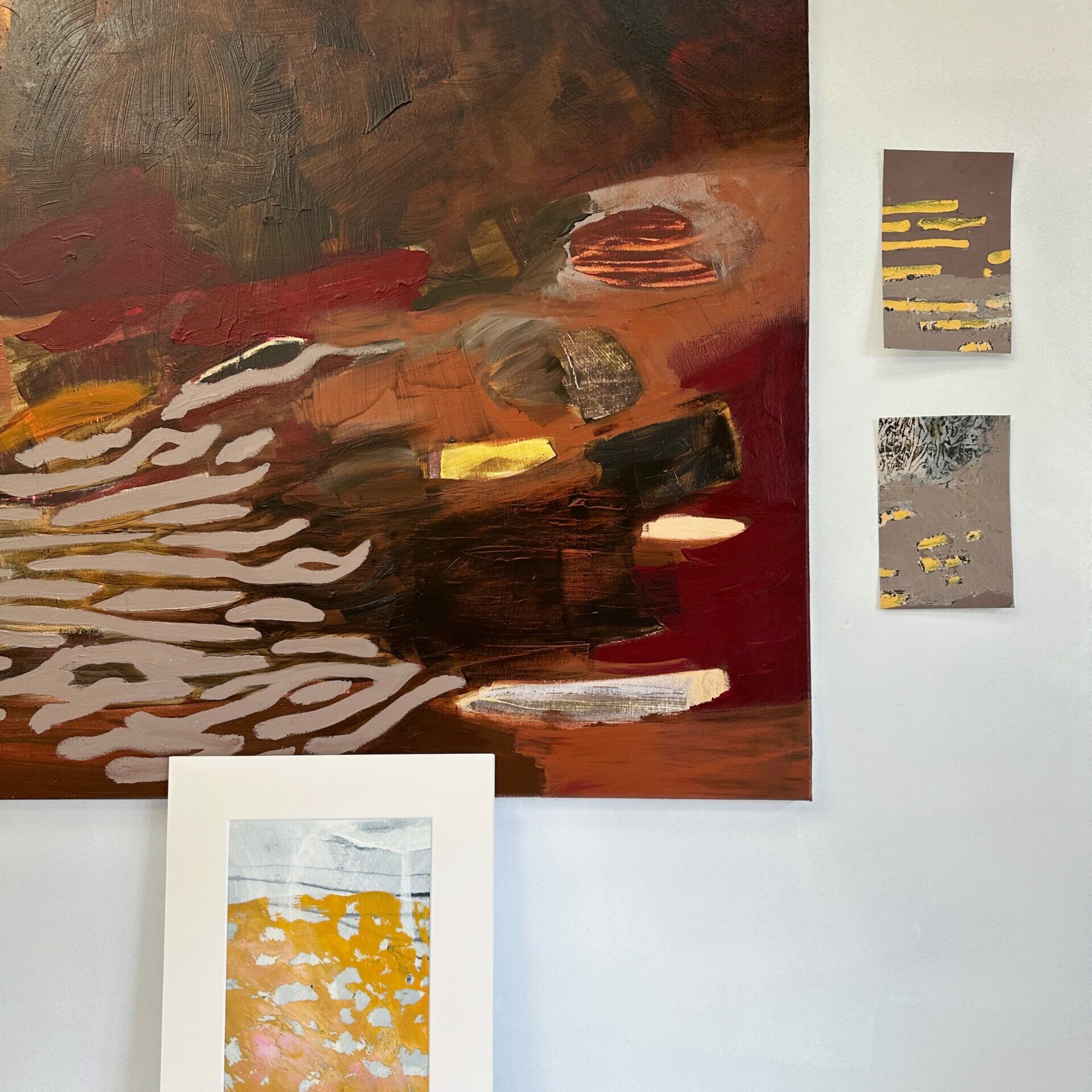 Work in progress in the studio; paintings in rusty brown and red, and yellow